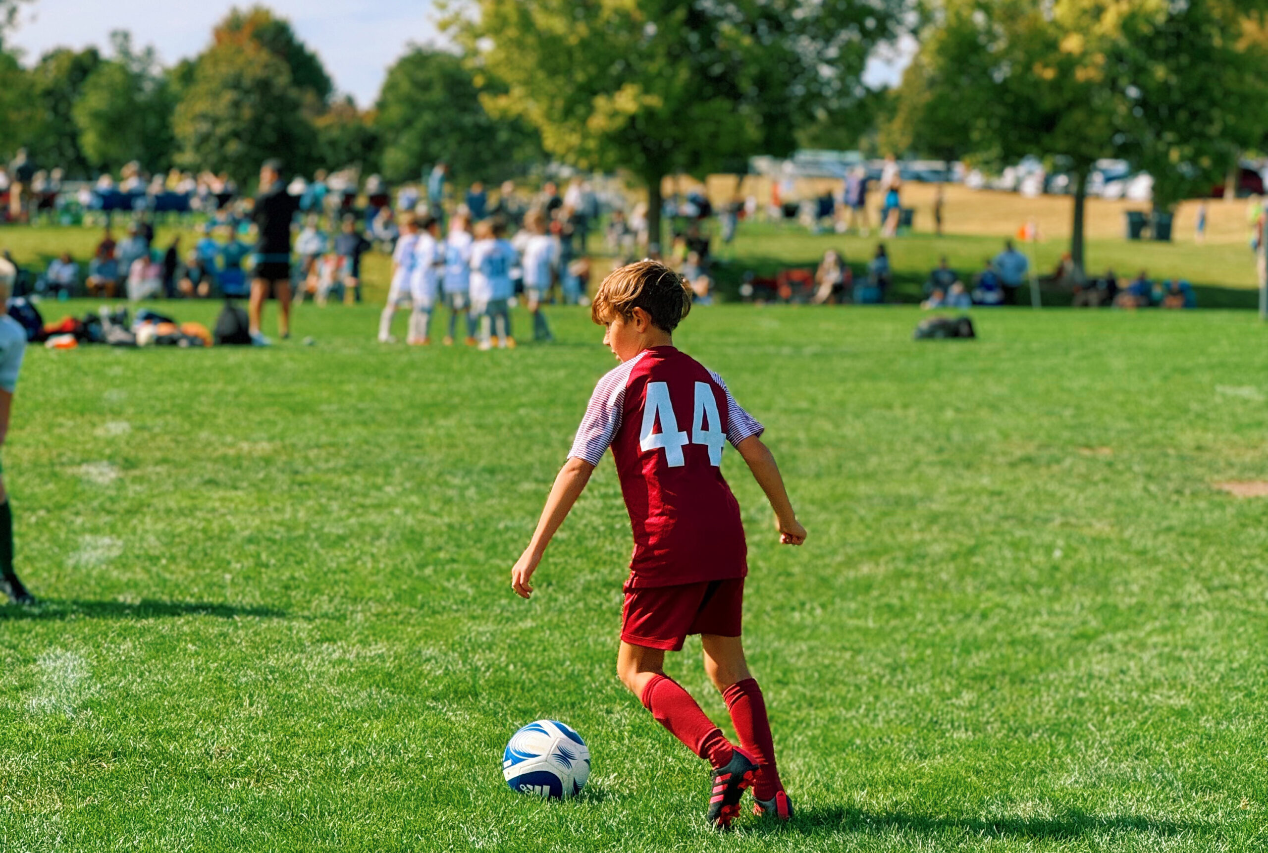 A boy kicks a ball on a soccer field